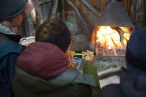 v.c.u. students gathered around a campfire eating dinner